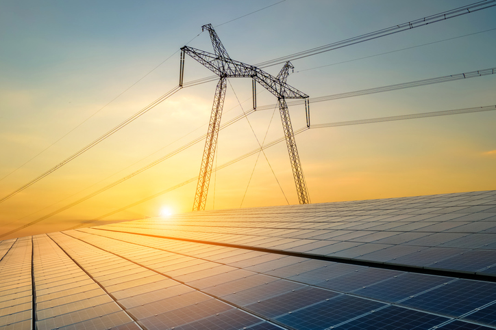Energy + power 1 Højspændingsmaster med elledninger, der overfører elektricitet fra solceller ved solopgang.