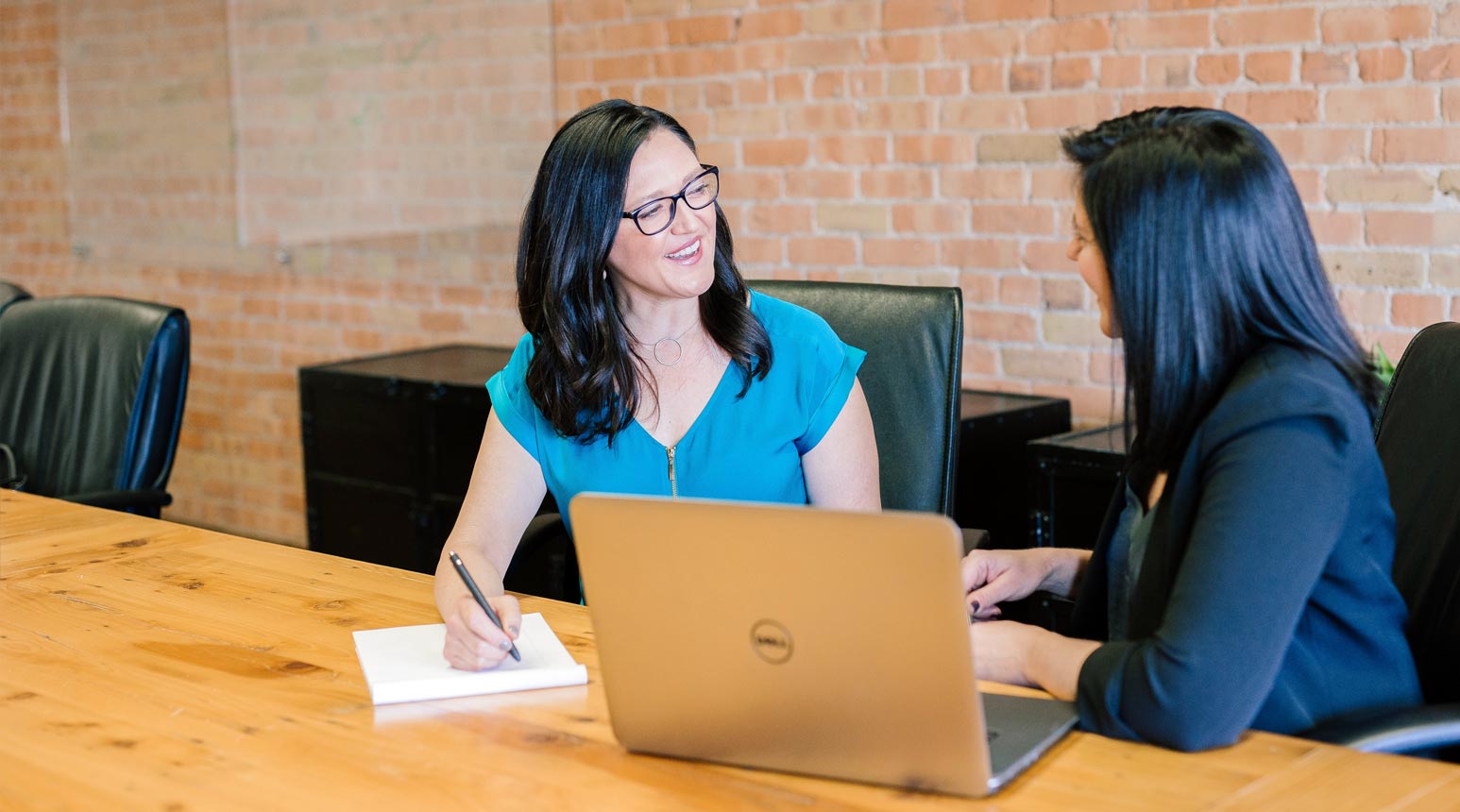 Two people in a meeting discussing unemployment compensation.