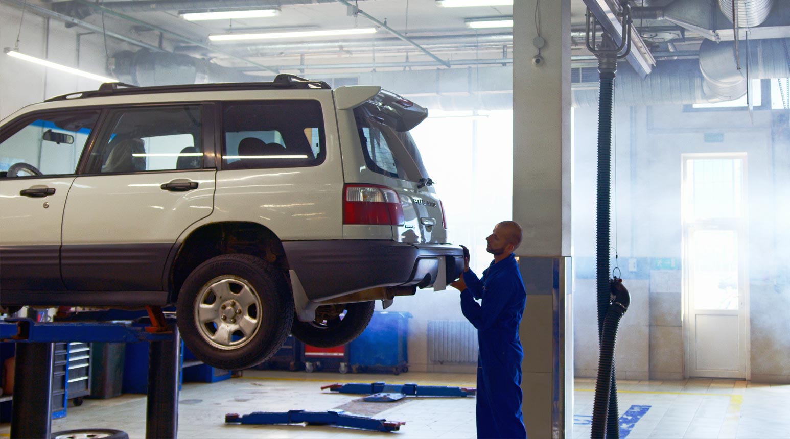 Direct repair program network 1 Une automobile sur un ascenseur dans un atelier de réparation automobile.